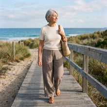 Woman in wide linen trousers on the beach boardwalk