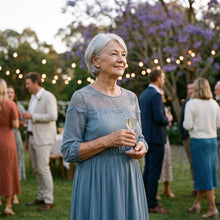 Woman in a blue lace-yoke dress at a garden party under a jacaranda