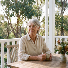 Woman in a cream linen blouse at the verandah table